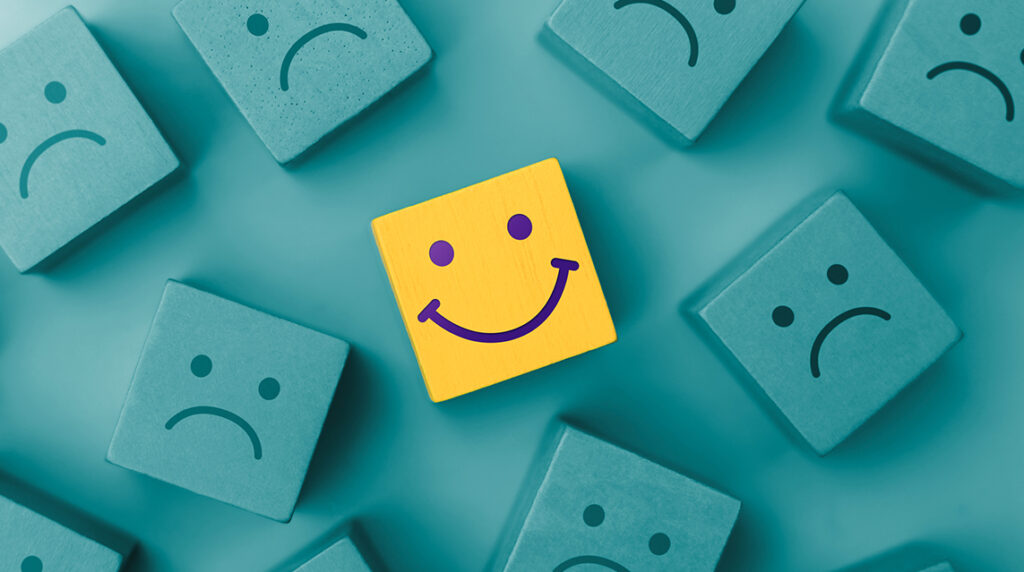 A group of blue unhappy face icons with one prominent yellow smiling face icon.